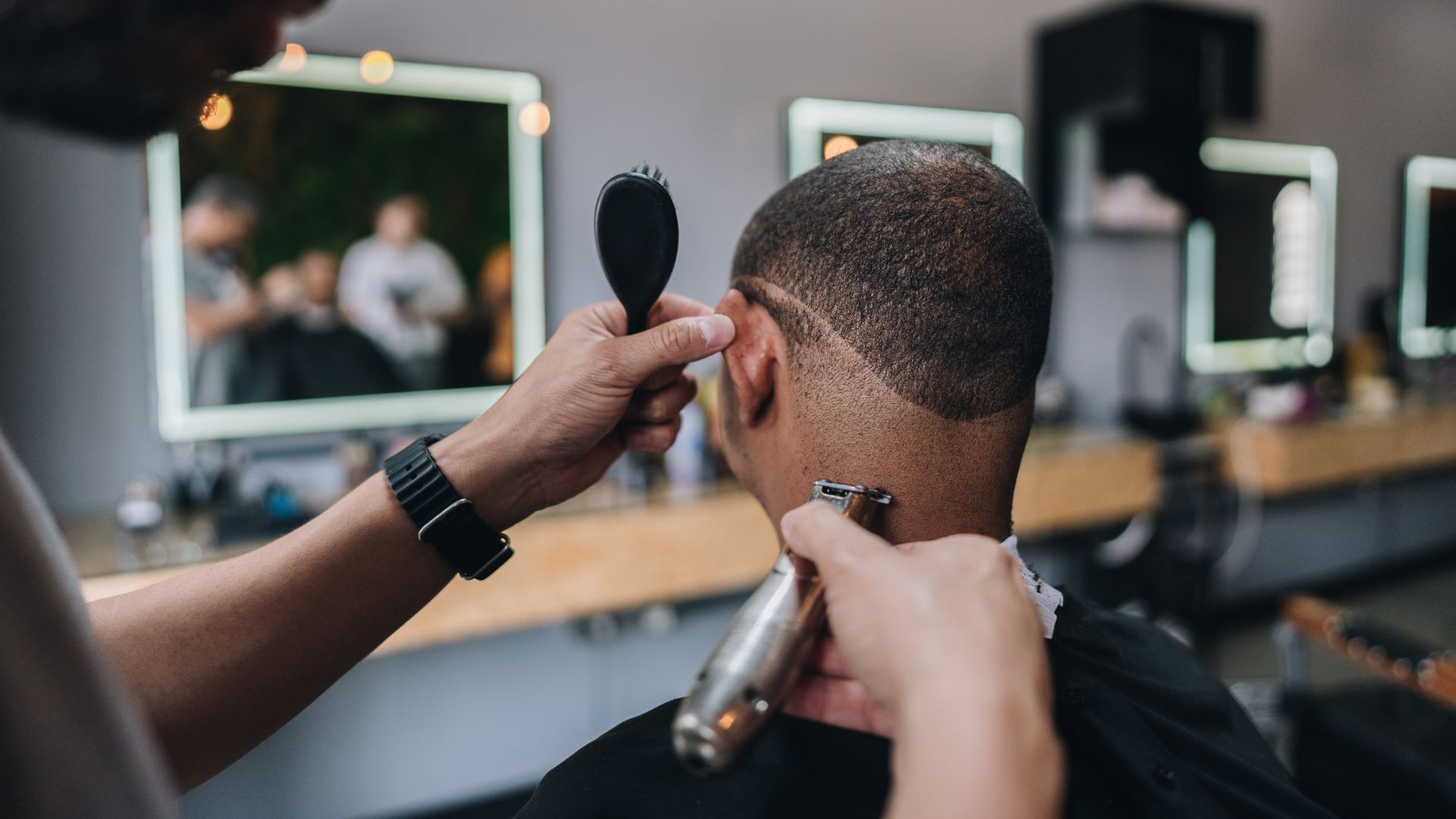 Barber running clippers through a fade at the barber chair