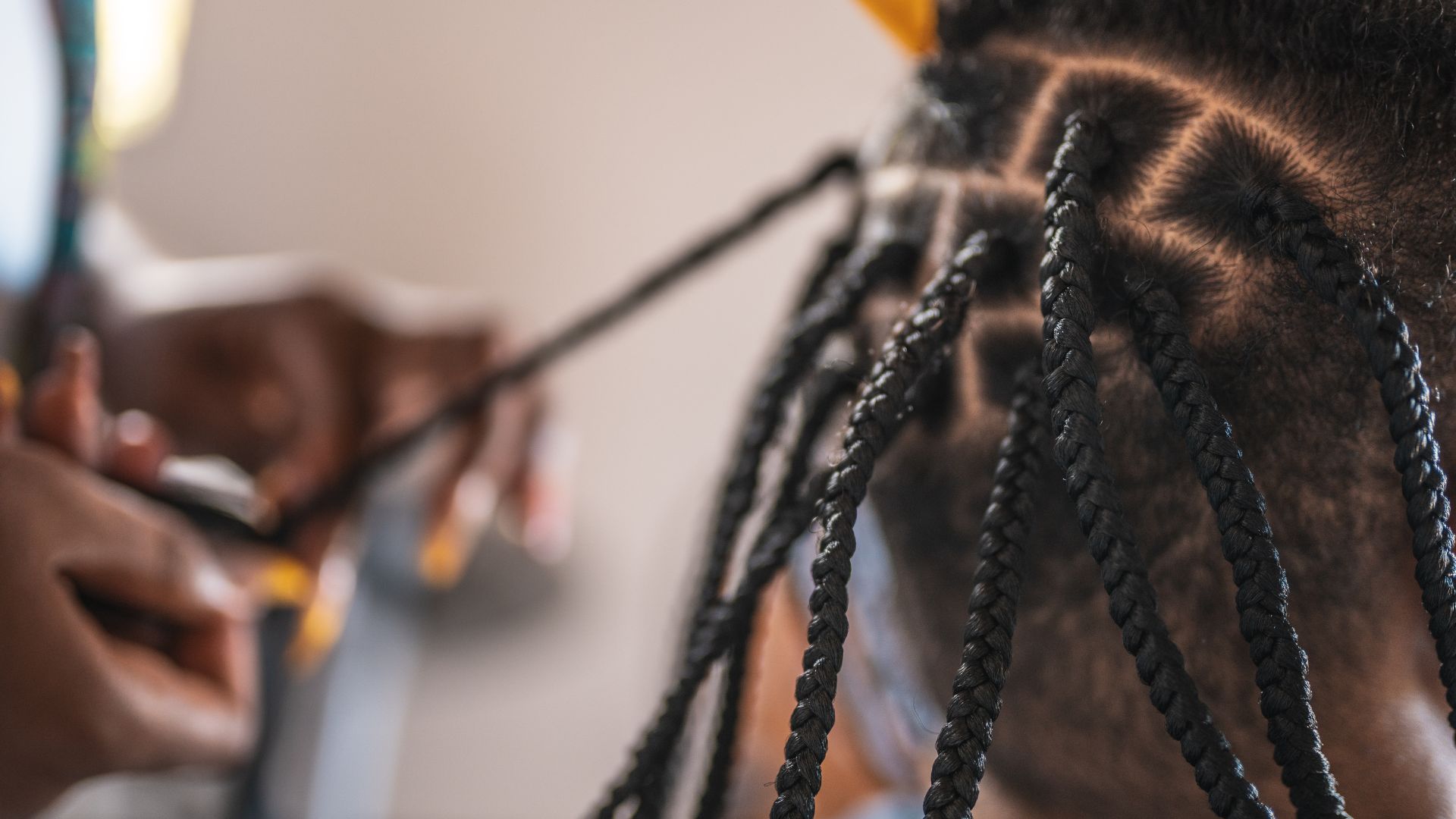 Close macro of hands sectioning and braiding hair
