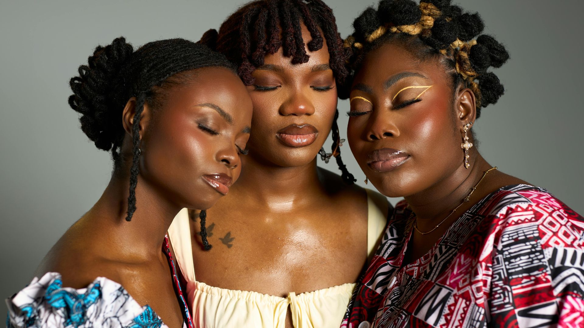 Three models showing locs, bantu-knot and braided styling