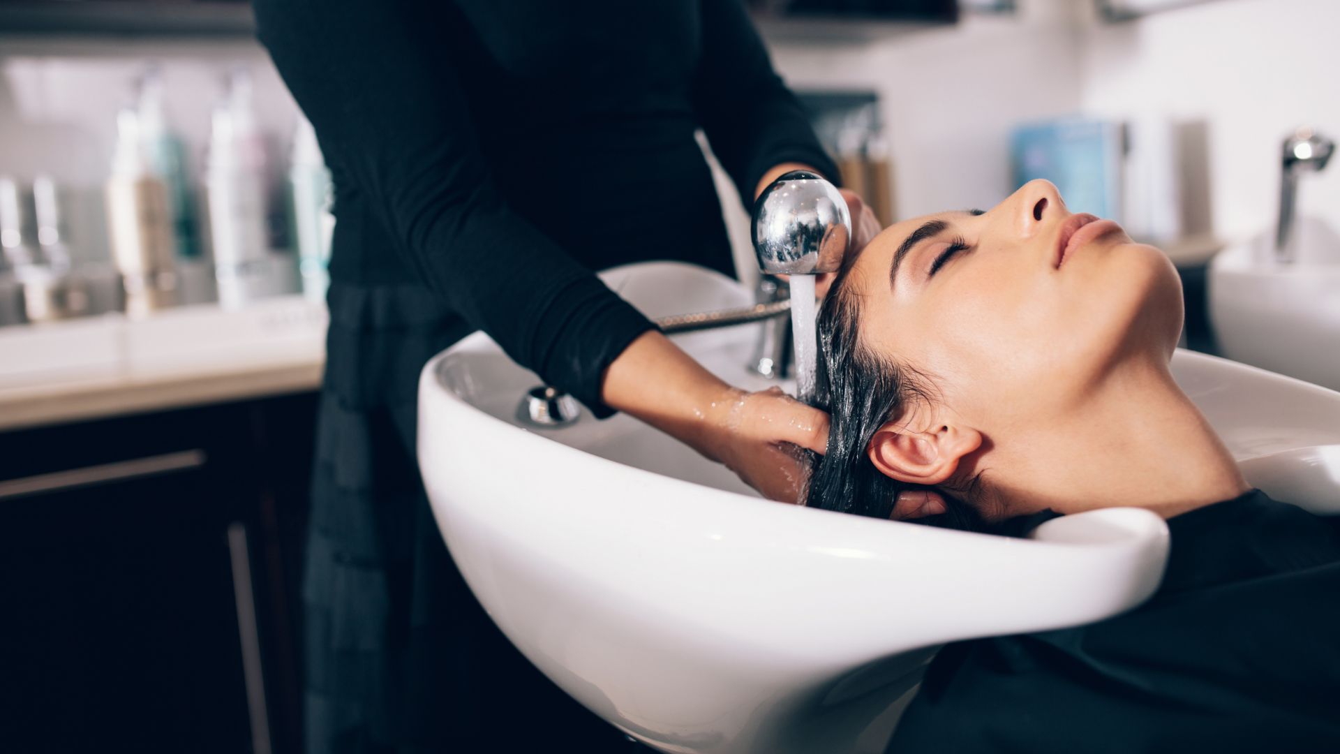 Hair being rinsed and treated at the wash basin