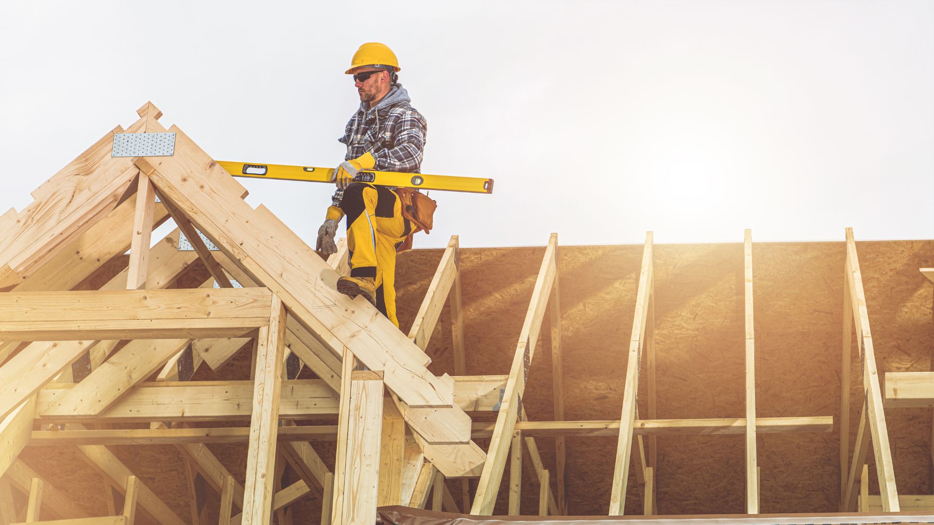 Timber and steel roof truss framing set out over a structure