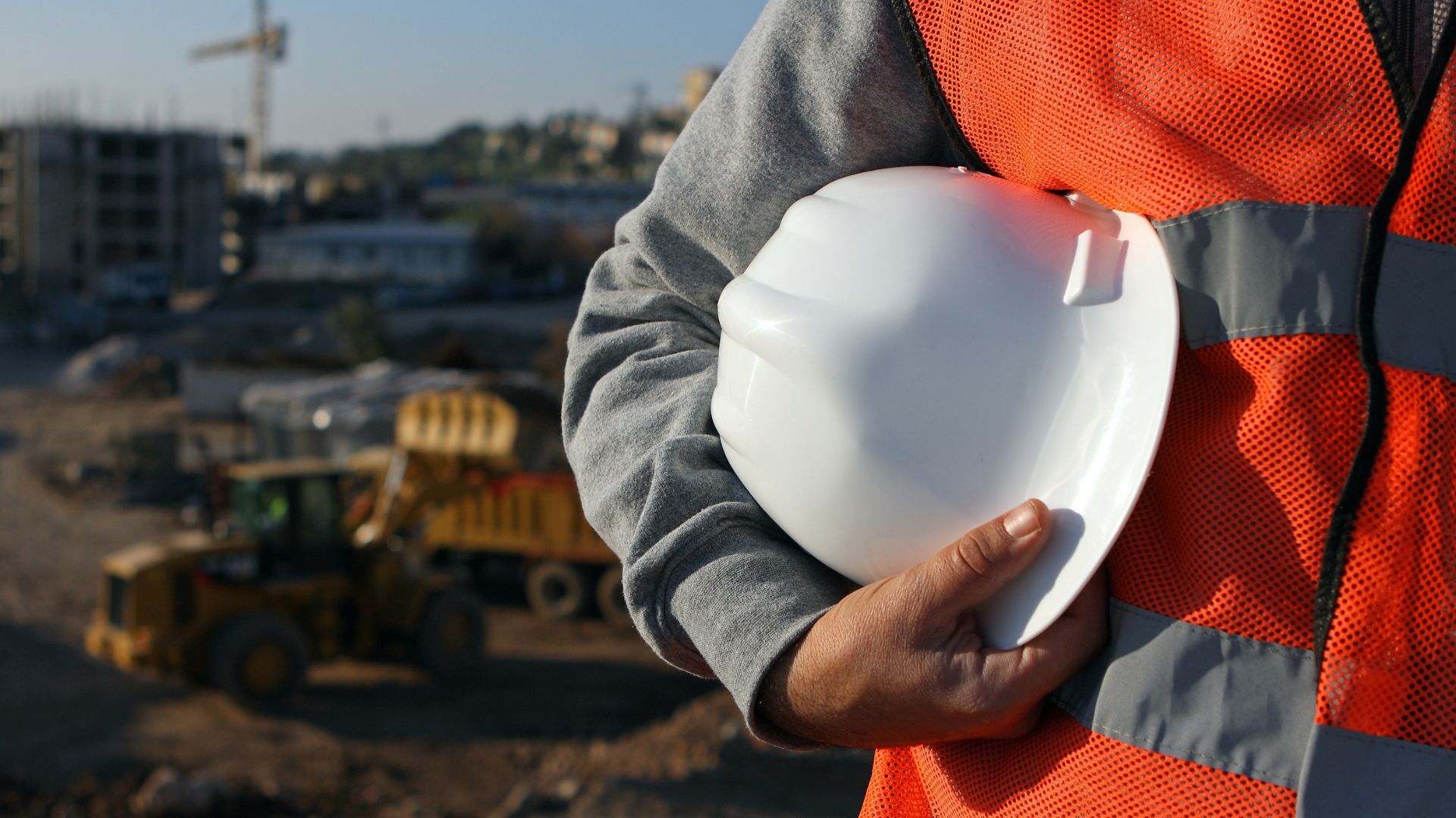 Site foreman in hard hat and safety gear on an active build