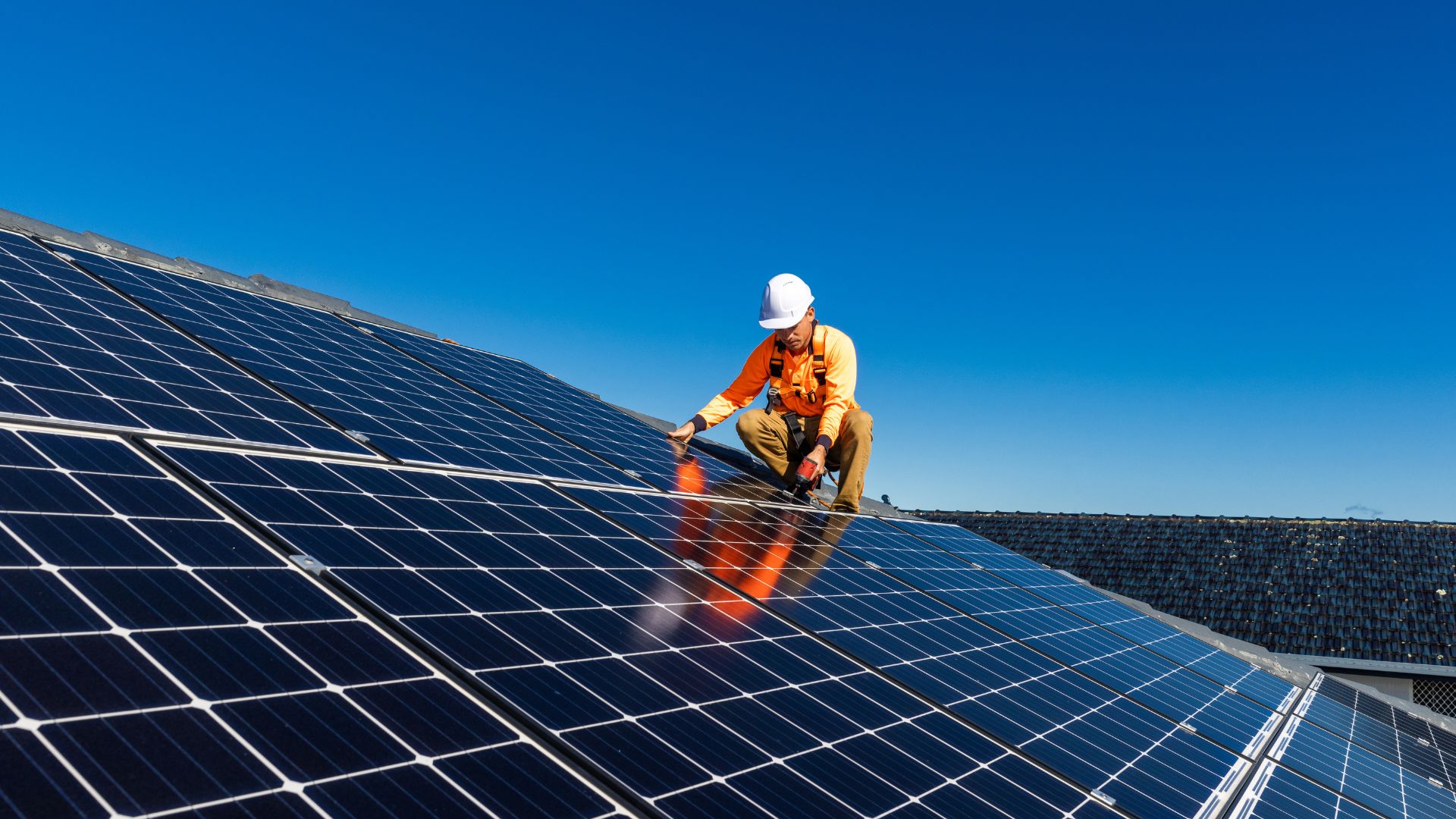 Technician installing rooftop solar photovoltaic panels
